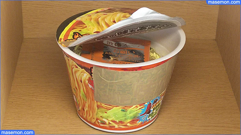 カップラーメンのフタを開ける